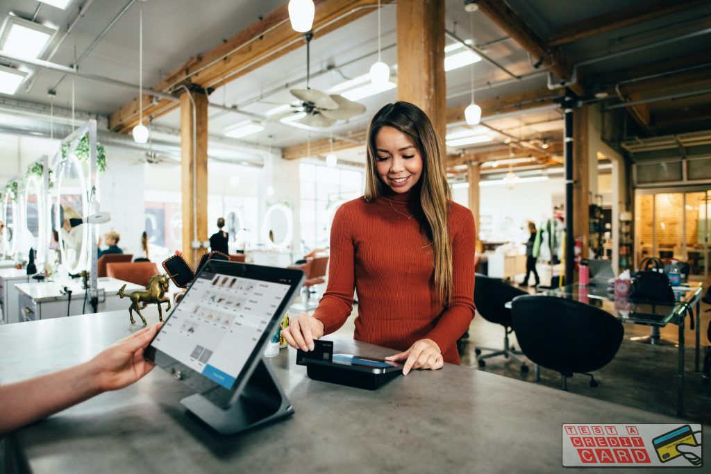 woman pays with a credit card at a counter